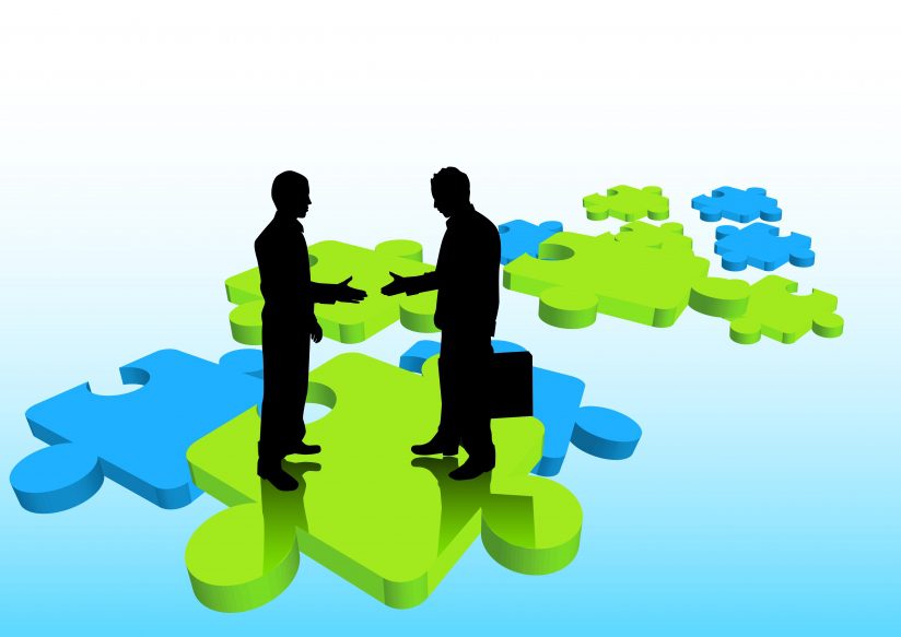 Two business man standing on top of puzzle pieces